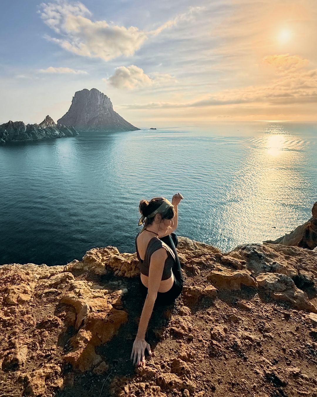 Marion face à la mer, au sommet d’une falaise au coucher du soleil